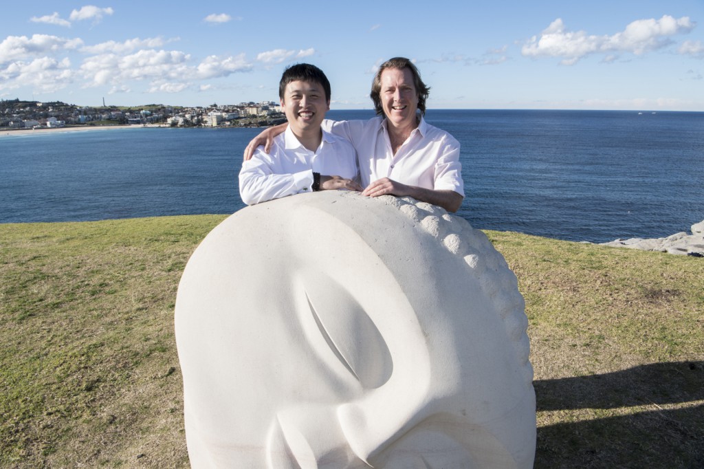 Mr Jin Lin, Managing Director of Aqualand & Mr David Handley AM, Founding Director of Sculpture by the Sea with 'Moon Buddha' by Vince Vozzo on south Bondi Beach headland on July 5, 2016 in Sydney, Australia. Aqualand is the new Principal Sponsor for the world's largest sculpture exhibition - Sculpture by the Sea, Bondi.